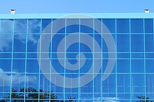 Part of modern building with blue windows with reflection