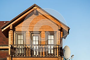 Part of modern wooden country house with blue sky on background. Roof of eco residential building near forest. Building