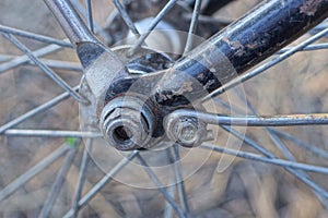 part of an old bicycle made of gray metal spoked wheels on a blue frame