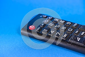 Part of old dirty tv remote console isolated on blue background