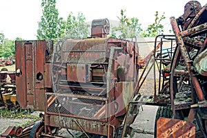 Part of an old rusty harvester at a scrap heap