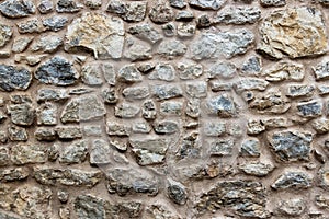 Part of old stone wall background. Rocks of different sizes and