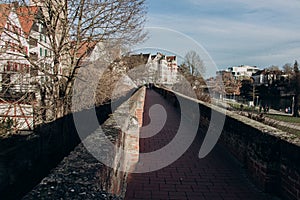 Part of the old stone wall of the city. Stadtmauer. View of the new part of Ulm from the Danube embankment photo