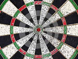 colorful grunge dartboard with red bullseye and porous caused by hard training