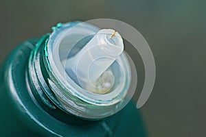 Part of one green plastic bottle with white open cap