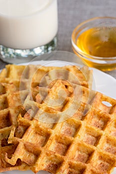 Part of orange waffles with glass of milk