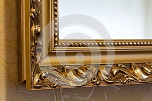 Part of the ornate, golden color carved mirror frame in ancient