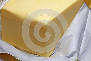 Part of a package of butter that is in gold foil
