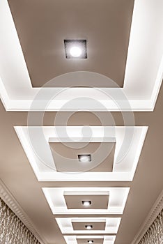 Part of the plasterboard ceiling decorated with ceiling lights and LED strip