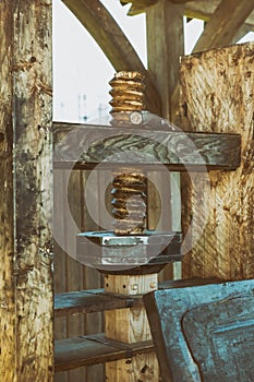 Part of the printing press mechanism, vertical wooden pressure plate screw close-up
