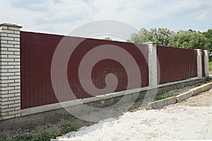 Part of a private wall of a fence made of red metal