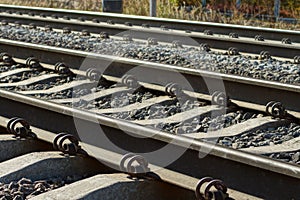 Part of the railway with gray iron rails and concrete sleepers