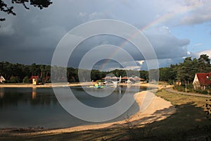 Part of Rainbow above lake of recreation area Landgoed `t Loo in the Netherlands.
