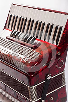 Part red musical instrument accordion, white background