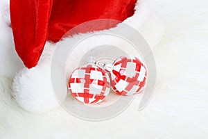 Part of Santa Claus hat with pom-pom and two red and white Christmas balls