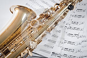 Part of saxophone lying on the notes