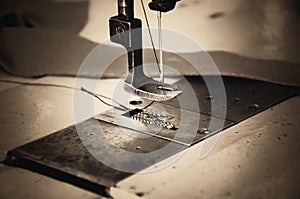 Part of sewing machine and fabric. horizontal, sepia, monochrom photo