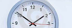 part of silver big analogue plain wall clock on trendy pastel blue background. copy space, time management concept and