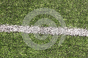 Part of sport soccer stadium and artificial turf football field. Detail, close up of green grass with white lines, goal line.