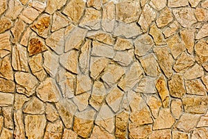 Part of a stone wall, brownish beige tones for background or texture.