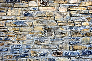 Part of a stone wall made of carved stone with different colors