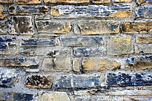 Part of a stone wall made of carved stone with different structure and color