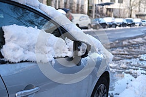 Part of street in city, pavement after heavy snowfall, wet snow melts, puddles, slush and mud impede movement of pedestrians and