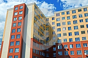 Part of a tall brown high-rise building with windows against the sky