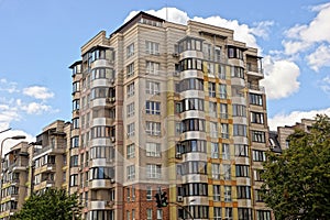 Part of a tall brown high-rise building with windows against the sky