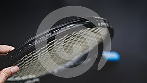 Part of tennis racket head on black background