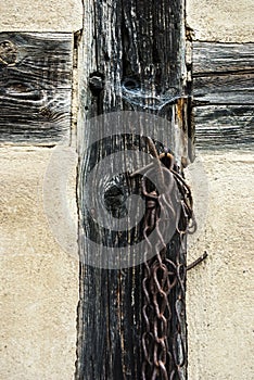Part of a truss with a rusted chain attached to a nail, Teil einers Fachwerks mit einer an einem Nagel aufghÃ¤ngten verr
