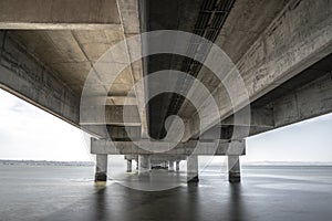 part under the Vasco da Gama bridge in perspective of infinity with the supporting pillars visible.
