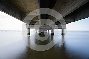 part under the Vasco da Gama bridge in perspective of infinity with the supporting pillars visible.