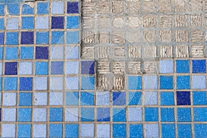 part of a wall in blue mosaic close-up on a gray plastered wall