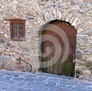 Part of the wall with a window and a door in the very old house, built in the 16th century