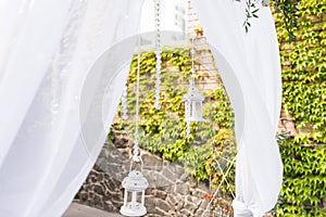 Part of wedding arch decorated with White lantern with a candle and a beautiful bunch of eucalyptus.