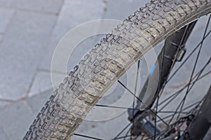 Part of a wheel made of gray black rubber tire and metal spokes