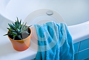 Part of white bath with azure blue towel