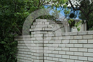 Part of a white brick wall of a fence