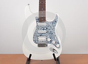 Part of white electric guitar, studio shoot.  2 x Single Coil and 1 x Humbucker. Black Pearl pickguard, Rosewood Fingerboard