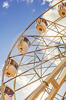 part of white ferris wheel against blue sky background. Vertical