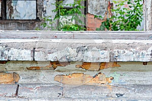 Part of the window sill and walls of an old half-destroyed building.