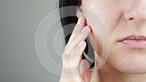 Part of a woman`s face close-up. The woman touches the skin on her face. Problem skin with enlarged pores.