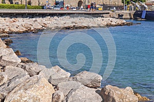 Part of wooden dock for walking with big sea stone on Greek iseland