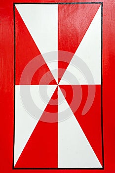 Part of wooden shutters with red and white pattern.