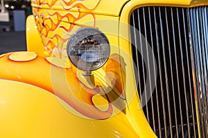 Part of a yellow classic old car with headlamp