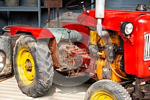 Partial close-up of a brand new red tractor in the countryside