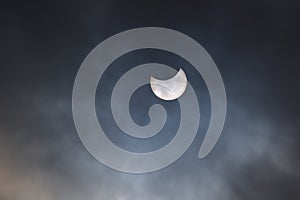 Partial eclipse of the sun on a cloudy sky