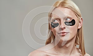 Partial image of guy with under eye patch on face