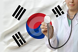 Partial photo of a girl doctor, nurse with a stethoscope in uniform against the background of the national flag of the state of